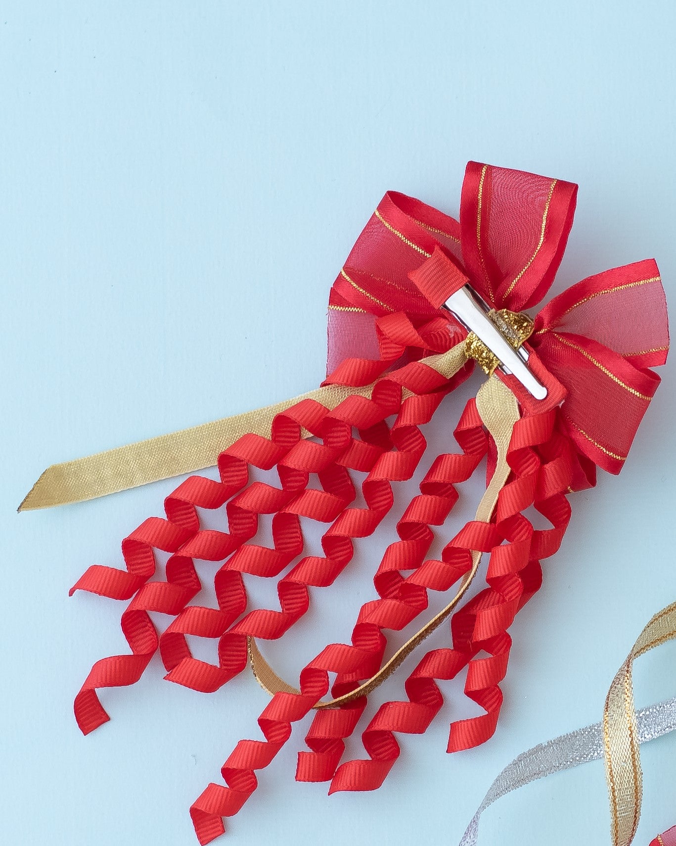 A pinwheel bow on alligator pins with danglers - Red, Gold