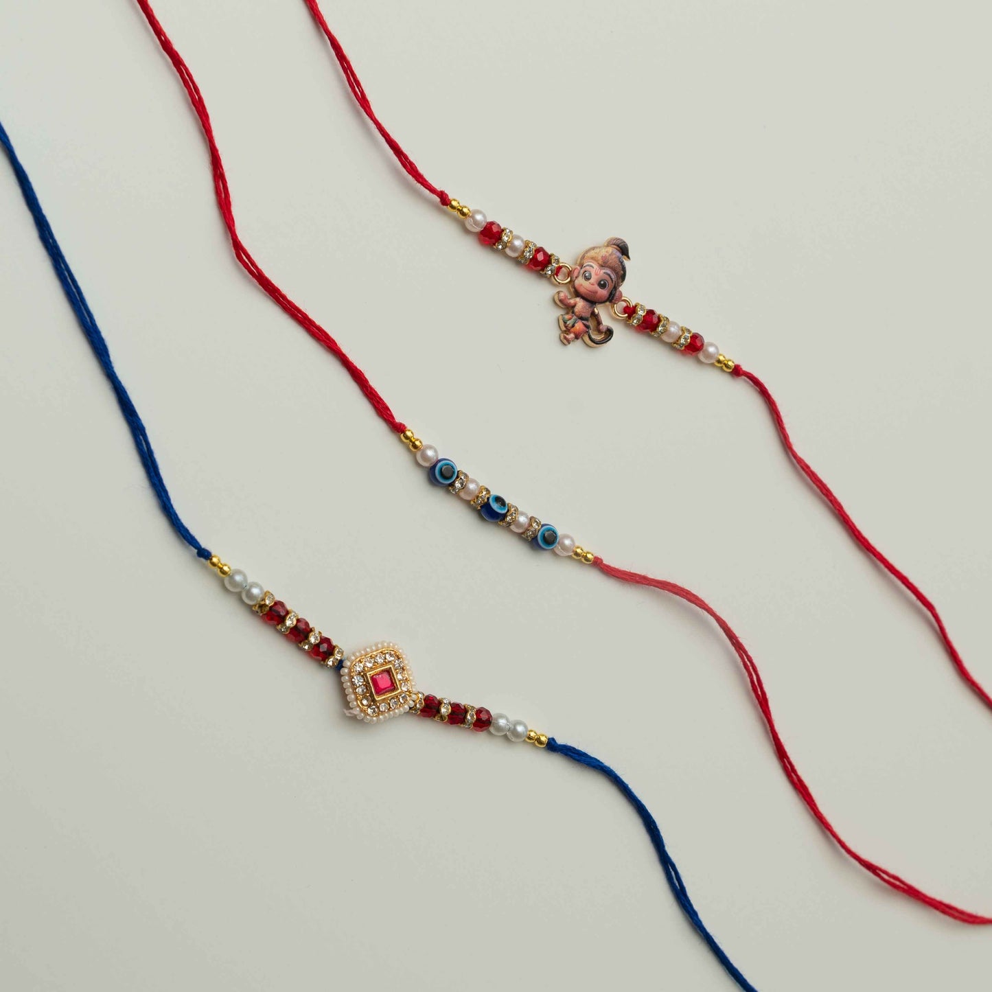 Set of 3 Rakhis, Little Hanuman, Evil Eye & Kundan Charm - Multicolor