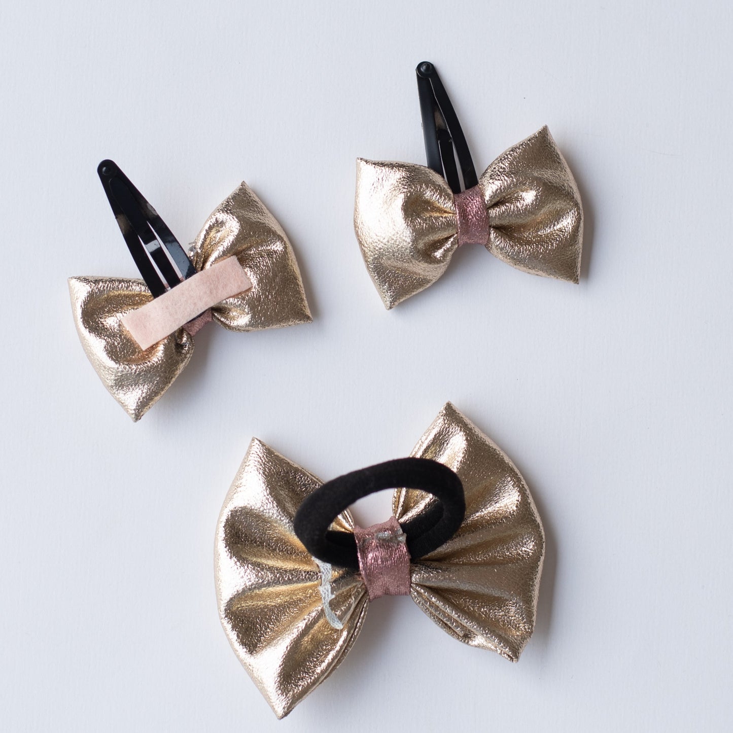Combo: Fancy gold shiny bow on tic-tac pins and one matching rubberband (3 nos) - Gold
