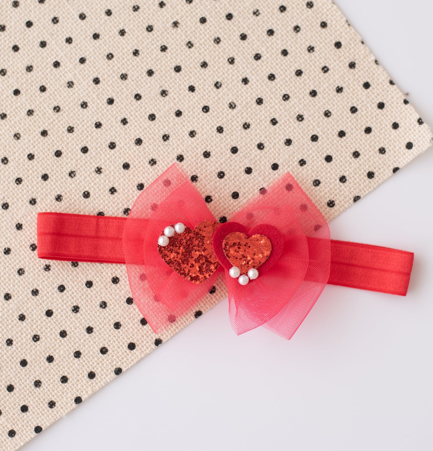 Beautiful red net bow with glitter hearts embellished with pearls on super soft stretchy band. - Red