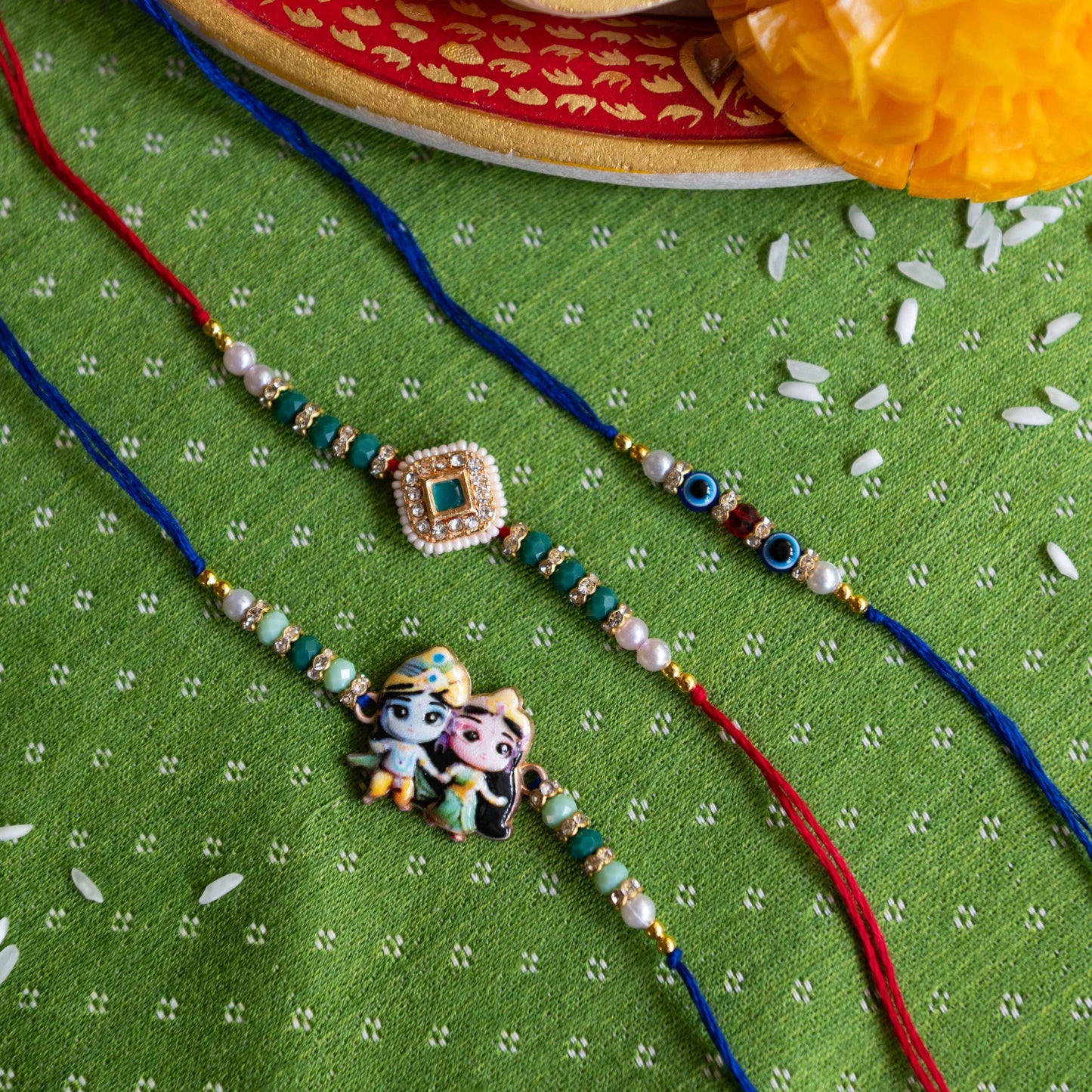 Ribbon Candy Set of 3 Rakhis-Radha Krishna,Kundan Charm & Evil Eye Beads - Blue, Red