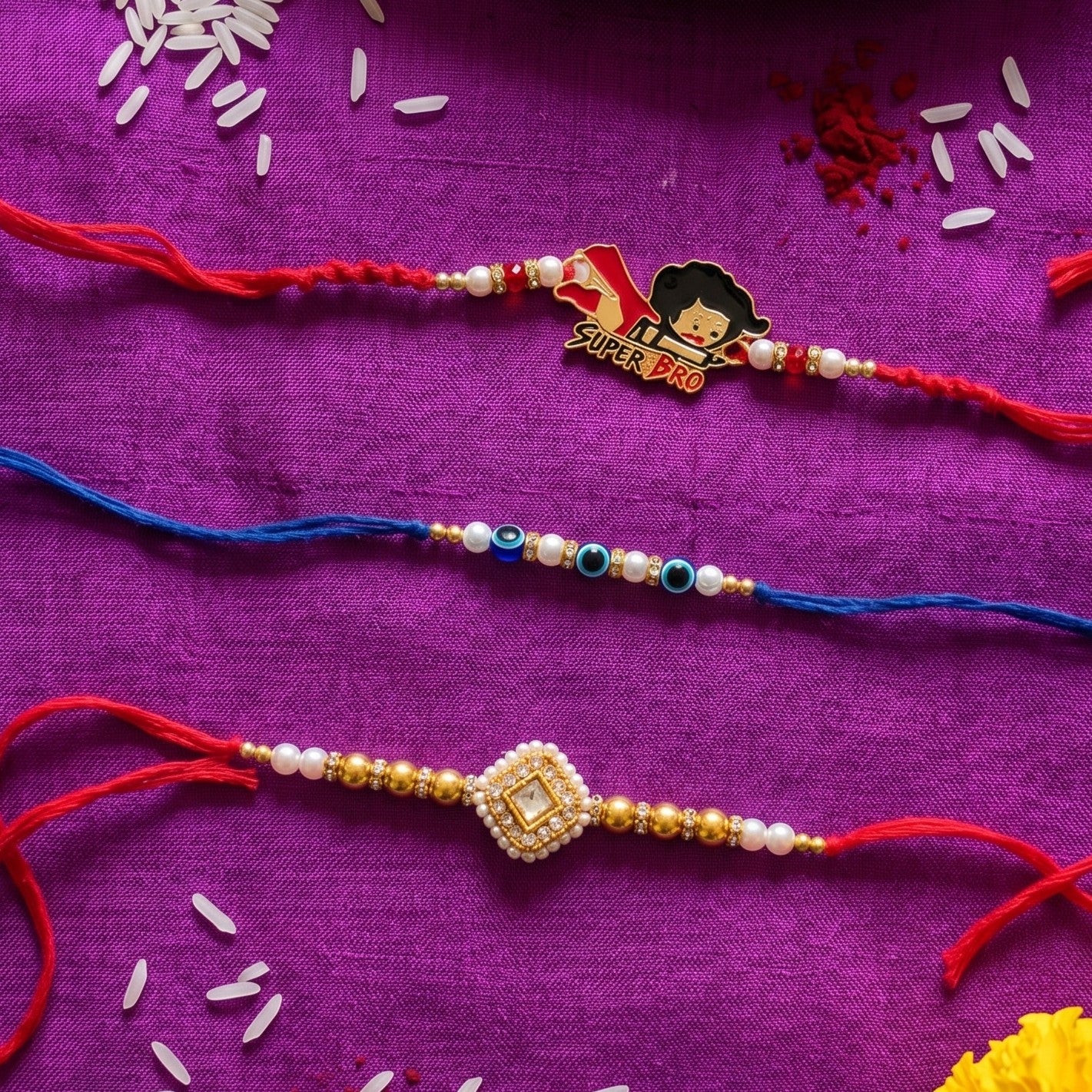 Ribbon Candy Set of 3 Rakhi-Kundann, Evil Eye, and 'Super Bro' Charm – Gold & Red