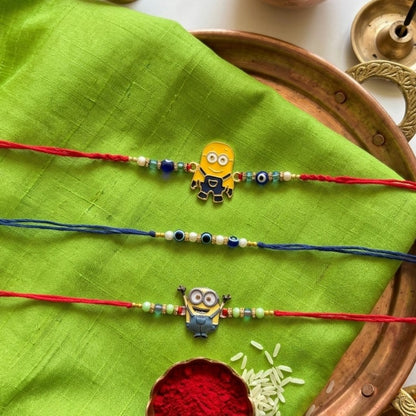 Ribbon Candy Set of 3 Rakhis-Cartoon Charms & Evil Eye Beads– Red & Blue